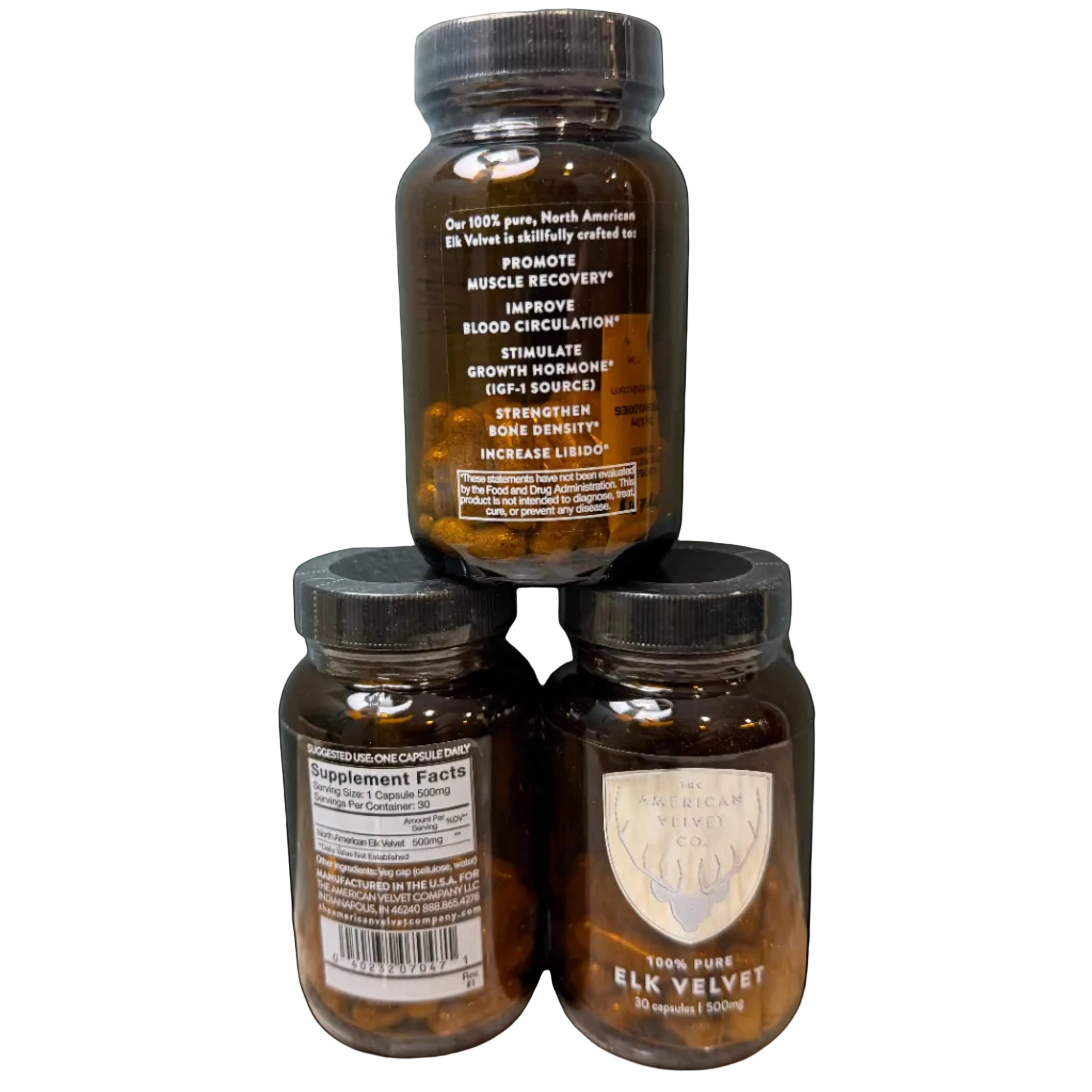Three amber supplement bottles with black caps arranged in a pyramid on a stone surface against a textured blue-gray wall. The top bottle is upright showing the back label, while the two lower bottles are turned sideways showing the front and back labels.